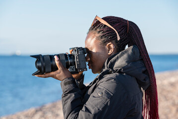 african hobbyist photographer out in nature and taking pictures with a mirrorless camera