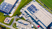 Industry With Low Carbon Footprint. Industrial Warehouses With Solar Panels On The Roof. Technology Park And Factories  From Above.