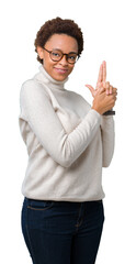 Wall Mural - Young beautiful african american woman wearing glasses over isolated background Holding symbolic gun with hand gesture, playing killing shooting weapons, angry face