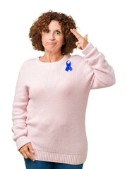 Sticker - Middle ager senior woman wearing changeable blue color ribbon awareness over isolated background Shooting and killing oneself pointing hand and fingers to head, suicide gesture.