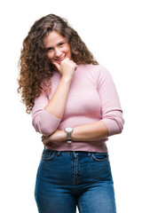 Poster - Beautiful brunette curly hair young girl wearing pink sweater over isolated background looking confident at the camera with smile with crossed arms and hand raised on chin. Thinking positive.