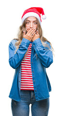 Poster - Beautiful young blonde woman wearing christmas hat over isolated background shocked covering mouth with hands for mistake. Secret concept.