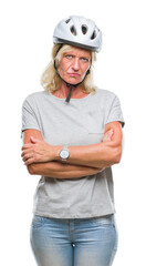 Canvas Print - Middle age caucasian cyclist woman wearing safety helmet over isolated background skeptic and nervous, disapproving expression on face with crossed arms. Negative person.