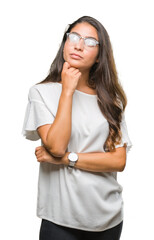 Wall Mural - Young beautiful arab woman wearing glasses over isolated background with hand on chin thinking about question, pensive expression. Smiling with thoughtful face. Doubt concept.