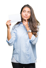 Poster - Young arab woman holding blank card over isolated background serious face thinking about question, very confused idea