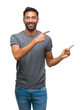 © Krakenimages.com - Adult hispanic man over isolated background smiling and looking at the camera pointing with two hands and fingers to the side.