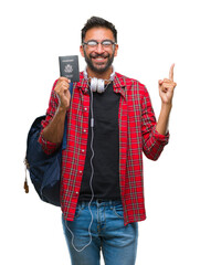 Poster - Adult hispanic student man holding passport of america over isolated background very happy pointing with hand and finger to the side