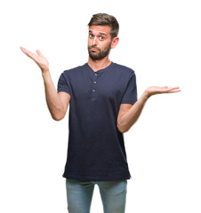 Wall Mural - Young handsome man over isolated background clueless and confused expression with arms and hands raised. Doubt concept.