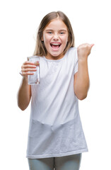 Young beautiful girl drinking glass of water over isolated background screaming proud and celebrating victory and success very excited, cheering emotion