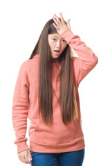 Sticker - Young Chinese woman over isolated background wearing sport sweathshirt surprised with hand on head for mistake, remember error. Forgot, bad memory concept.