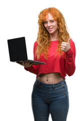 Poster - Young redhead woman using computer laptop happy with big smile doing ok sign, thumb up with fingers, excellent sign