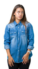 Sticker - Young beautiful brunette woman wearing blue denim shirt over isolated background making fish face with lips, crazy and comical gesture. Funny expression.