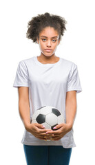 Canvas Print - Young beautiful afro american holding soccer football ball over isolated background with a confident expression on smart face thinking serious