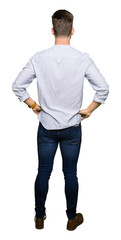 young handsome man standing backwards looking away with arms on body