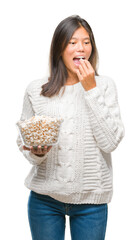 Canvas Print - Young asian woman eating popcorn over isolated background with a confident expression on smart face thinking serious