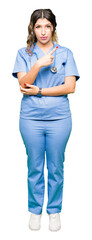 Poster - Young adult doctor woman wearing medical uniform Pointing with hand finger to the side showing advertisement, serious and calm face