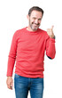 © Krakenimages.com - Handsome middle age hoary senior man wearing winter sweater over isolated background doing happy thumbs up gesture with hand. Approving expression looking at the camera showing success.