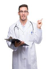 Sticker - Handsome young doctor man holding a clipboard very happy pointing with hand and finger to the side