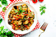 Vegetable stew, saute or caponata. Stewed eggplant with paprika, tomatoes, spices and herbs. White kitchen table background, top view, copy space