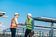 © Johnstocker - Two engineers are shaking hands at solar farm