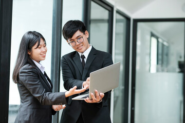 Two businesspeople talking and discussing while standing.