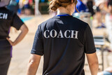 Fototapeta  - Back view of swimming coaches, wearing COACH shirt