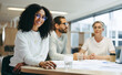 © Jacob Lund - Cheerful young businesswoman attending a meeting with her team
