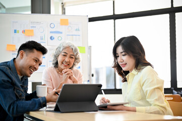 Professional-aged Asian female boss satisfied with her marketing campaign results