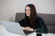 © hurricanehank - Happy brunette woman working on laptop at home. Cheerful white female person doing work on notebook computer