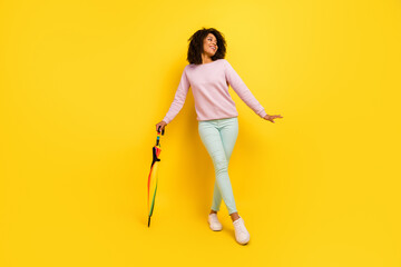 Wall Mural - Full size photo of young pretty woman good mood hold parasol look empty space isolated over yellow color background