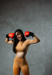 Young beautiful fit woman posing with red boxing gloves.
