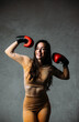 Young beautiful fit woman posing with red boxing gloves.