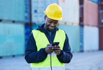 Social media, logistics and employee working in shipping typing on a mobile app with phone at a port. Happy African warehouse man reading an email or communication on a smartphone at industrial site