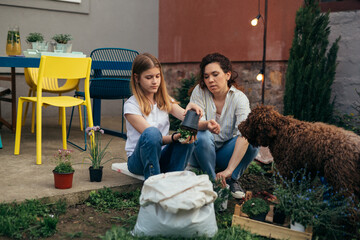 Wall Mural - mother and daughter gardening flowers in backyard