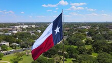 Orbital Shot Of Texas Flag With The City Of Austin, Texas In The Background.