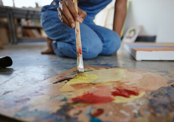 Wall Mural - Artist woman, painting and paint brush on art studio floor being creative and working with watercolor for artwork project. Talented, skill and canvas closeup with hand of a female painter in workshop