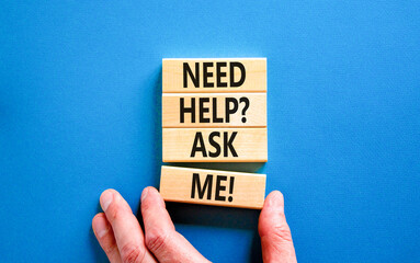 Support and need help ask me symbol. Concept words Need help ask me on wooden blocks on a beautiful blue table blue background. Businessman hand. Business, support and Need help ask me concept.