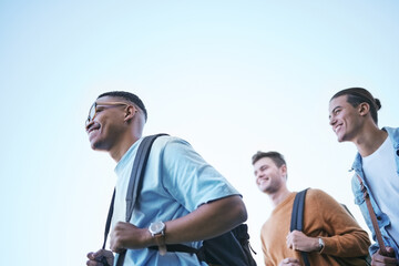 Wall Mural - Education, friends and students walking to university campus with backpack low angle. Scholarship, diversity and happy people ready for learning, studying or academic work in the morning in college