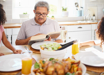 Food, family and books with grandfather reading to children at a table, bonding and storytelling before sharing a meal. Bible, religion and senior man teaching grandkids faith and scripture in home