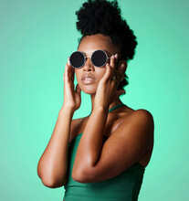 Fashion, Black Woman And Glasses With A Model In Studio On A Green Background With Vintage Or Retro Sunglasses Or Eyewear. Trendy, Style And Confident With A Young African American Female With Afro