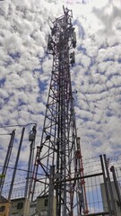 telecommunications tower in the fence and cloudy sky