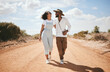 © S Fanti/peopleimages.com - Love, couple and summer with a black woman and man walking on a sand road in the dessert while on vacation. Romance, dating and holiday with a young male and female on a walk together in nature