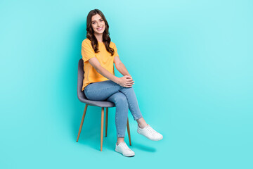 Wall Mural - Full length photo of sweet pretty girl dressed yellow t-shirt smiling sitting chair empty space isolated teal color background