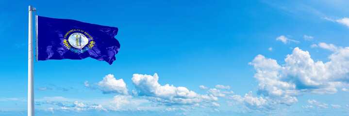 Wall Mural - Kentucky - state of USA, flag waving on a blue sky in beautiful clouds - Horizontal banner
