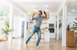 © paulaphoto - Portrait of senior old caucasian white man stay home dance in living room listen to music head phone. Happy moment of modern middle age male relax with online digital technology song in winter