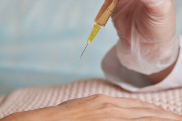 Doctor doing stem cell therapy on a patient's elbow after the injury. Treating knee pain with platelet-rich plasma injection. Treatment of arthritis and osteoarthritis.Medical and cosmetology concept.