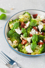 Wall Mural - healthy broccoli salad with feta cheese sun dried tomatoes pine nuts. vegetarian low carb keto diet