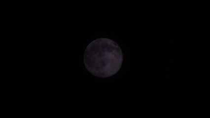 Wall Mural - Magical full moon at night. Telephoto view of mysterious clouds flying against the bright full moon. Real midnight footage with black background and copy space. Creepy halloween sky, astrology concept