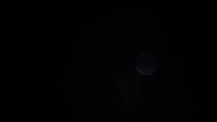 Wall Mural - Magical full moon at night. Telephoto view of mysterious clouds flying against the bright full moon. Real midnight footage with black background and copy space. Creepy halloween sky, astrology concept