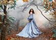 Queen woman walks in mystical autumn misty forest. Orange foliage gothic trees mist smoke. Hair flying in wind motion princess girl looks around. Medieval royal vintage long blue dress, puffy sleeves